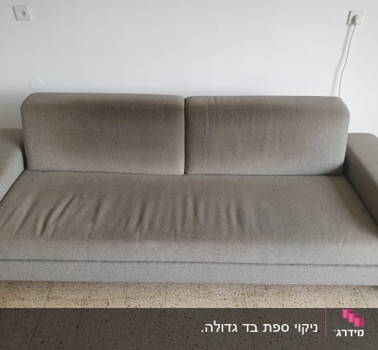 ספה אפורה עם כתמי לכלוך על המושב והמשענת